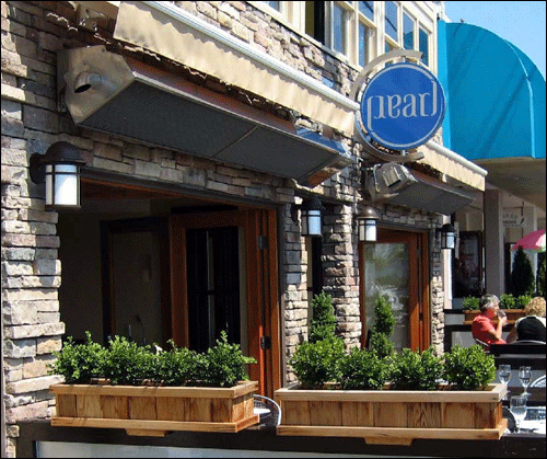 outdoor infrared heaters mounted above sidewalk cafe